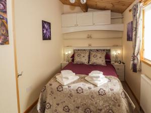 a bedroom with a bed with towels on it at Brookside Lodge in Worcester