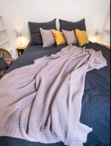 een deken op een bed met veel kussens bij Haus Sebald in Sankt Martin