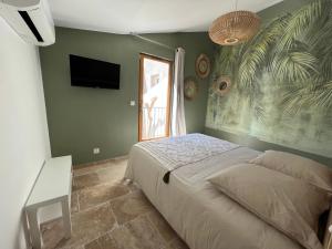 - une chambre avec un lit et une télévision à écran plat dans l'établissement Maison T4 centre ville et plage, à Balaruc-les-Bains
