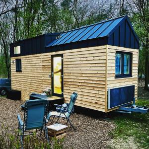 a wooden tiny house with a blue roof at Tinyhouse „Kleines Ems-Idyll“ in Lathen