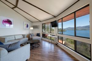 Depe Dene Lakeside Resort في بحيرة جورج: غرفة معيشة بنوافذ كبيرة وإطلالة على بحيرة