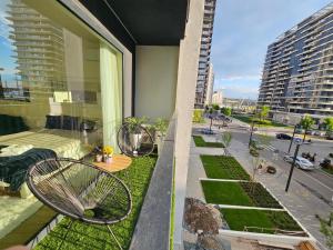 einen Balkon mit 2 Stühlen und einen Garten auf einem Gebäude in der Unterkunft Belgrade Waterfront - Beograd na vodi in Belgrad