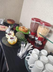 a table filled with food and a blender with food at Hotel Avenida in Bauru