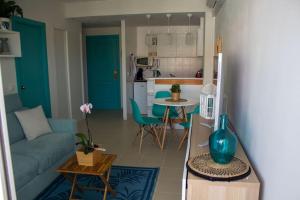 sala de estar con sofá azul y cocina en Alegre apto con piscina, a 300m de la playa., en Blanes