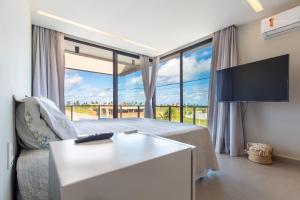 una camera da letto con un letto e una grande finestra di Bosque da Praia #29 - Casa em Jacumã por Carpediem a Ceará-Mirim