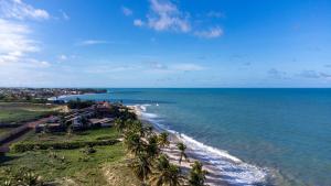una vista aerea di una spiaggia con palme di Bosque da Praia #29 - Casa em Jacumã por Carpediem a Ceará-Mirim Altre 39 foto