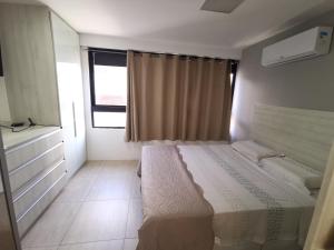 Un dormitorio con una cama grande y una ventana en Boa Viagem - Charmoso apartamento para casais, en Recife