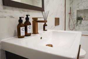 two bottles of wine sitting on a bathroom sink at Berry's Retreat - Kist Accommodates in Knaresborough