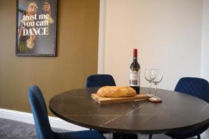 een tafel met een fles wijn en een glas bij Berry's Retreat - Kist Accommodates in Knaresborough