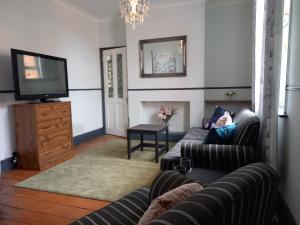 Charming 4-Bed Victorian House in Retford في ريتفورد: غرفة معيشة مع كنبتين وتلفزيون