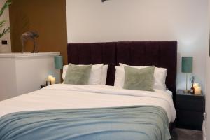 a bedroom with a large white bed with green pillows at Berry's Retreat - Kist Accommodates in Knaresborough