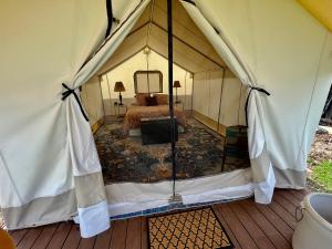 a bedroom in a tent with a bed in it at Zinnia Glamping Tent at Zenzen Gardens in Paonia