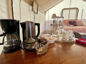 una mesa con cafetera y otros artículos. en Zinnia Glamping Tent at Zenzen Gardens en Paonia