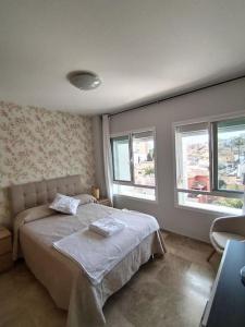 1 dormitorio con 1 cama y 2 ventanas en Apartamento tranquilidad, playa,wifi, en Torremolinos