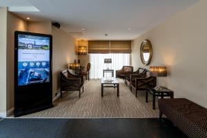 a living room with a large screen in a hotel room at Gresham Belson Hotel Brussels in Brussels