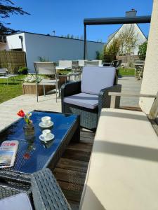 a patio with a blue table and chairs on a deck at Hôtel Restaurant La Voile Bleue in Erdeven