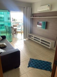 ein Wohnzimmer mit Couch und Flachbildfernseher in der Unterkunft Fiori Prime - Vista Entardecer e Piscina in Caldas Novas + 9 Fotos