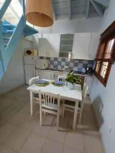 a kitchen with a white table and chairs at The House in the Mulberries Trees in Metangítsion