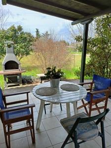 a patio with a table and chairs and a fireplace at The House in the Mulberries Trees in Metangítsion