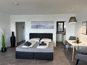 a bedroom with a large bed and a dining room at TTP 16 Friedrichshafen in Friedrichshafen