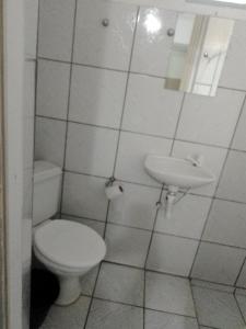 a bathroom with a toilet and a sink at Hotel Avenida in Bauru