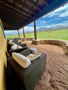 a row of couches sitting on top of a patio at Zinnia Glamping Tent at Zenzen Gardens in Paonia