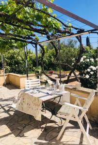 uma mesa e cadeiras sentadas sob uma pérgola em Appartement dans maison avec piscine et jardin 4 ou 6 personnes em Arles
