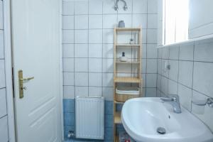 een witte badkamer met een wastafel en een plank bij Marilia’s apartment in Kanálion