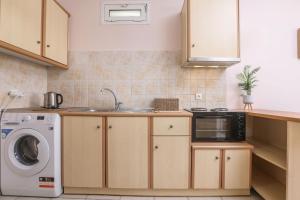 een keuken met een spoelbak en een wasmachine bij Marilia’s apartment in Kanálion +4 foto's