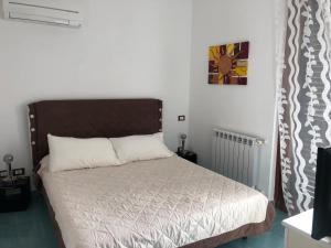 een slaapkamer met een bed in een kamer bij B&B Regina Viarum in Minturno