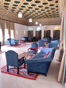 a waiting room with blue couches and chairs at Hotel Parador in Laayoune