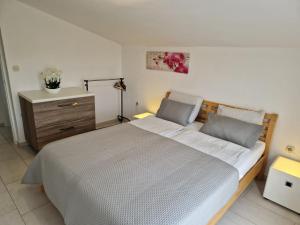 a bedroom with a large bed and a dresser at Apartment Vilic in Pula