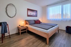 1 dormitorio con cama y espejo en la pared en Ferienhaus DAS GLAB en Velden am Wörthersee
