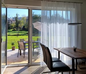 a dining room with a table and a sliding glass door at Ferienhaus DAS GLAB in Velden am Wörthersee