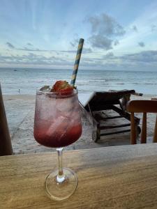 una copa en una copa sentada en una mesa cerca de la playa en Pousada Estrela Peroba, en Icapuí