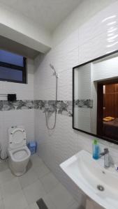 MENBi's Apartment في Kitimē: حمام مع مرحاض ومغسلة ومرآة
