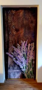 una pintura de flores púrpuras en una pared de madera en Vila Ema-kuća za odmor en Ludbreg