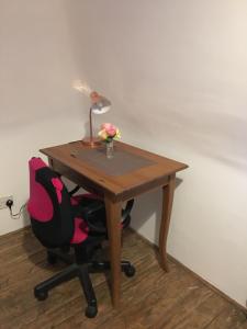 einen Schreibtisch mit einer Lampe und einem Stuhl mit einer Blumenvase in der Unterkunft Moore Crescent in Barking