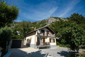 a white house with a mountain in the background at Apartment house Silvia in Grižane