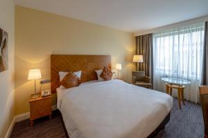 a hotel room with a large bed and a desk at Gresham Belson Hotel Brussels in Brussels