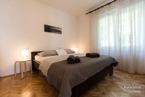een slaapkamer met een groot bed en een groot raam bij House Silvia in Grižane