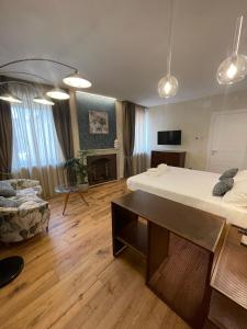 une chambre avec deux lits et un salon avec un canapé dans l'établissement La Bartolomea Home & Suite, à Pitigliano
