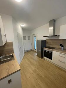 een keuken met witte muren en houten vloeren en een aanrecht bij Ferienhaus Wehretal 