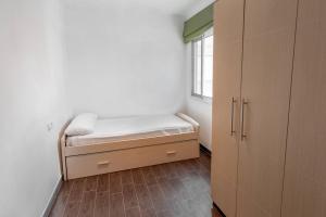a small bedroom with a bed and a window at Apartamento céntrico en Peñiscola in Peñíscola