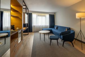 a living room with a blue couch and a table at Gresham Belson Hotel Brussels in Brussels