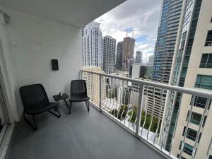 a balcony with two chairs and a view of a city at **New** Cozy and Detailed Brickell Studio in Miami