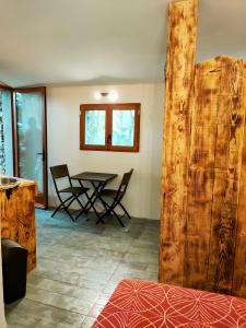 a room with a table and chairs and a wooden door at Cabane des pachous in Tourves