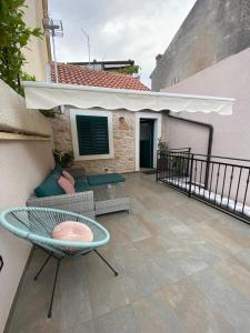 een patio met een bank en een tafel op een balkon bij Little Oasis in Šibenik