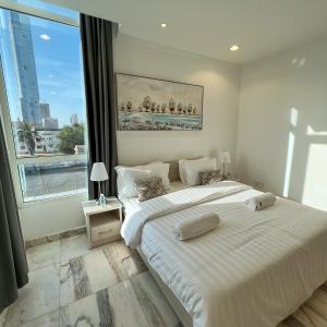 a bedroom with a large bed and a large window at Urban Luxury Apartment in Jeddah