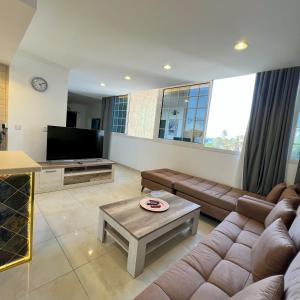 a living room with a couch and a tv at Urban Luxury Apartment in Jeddah